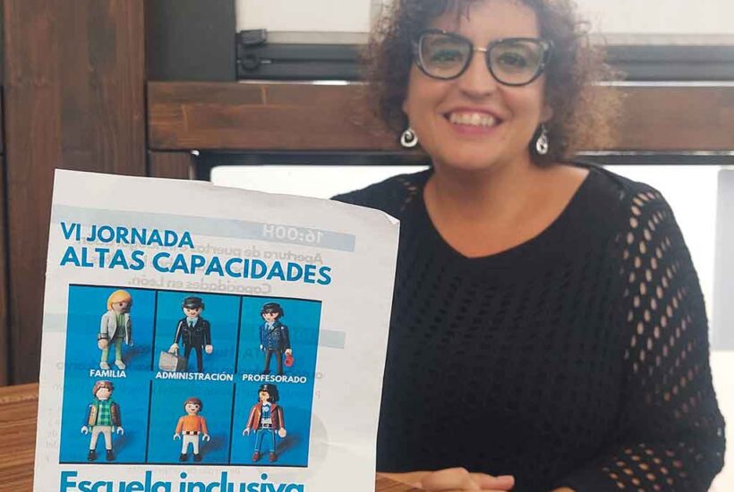 La maestra Susana Morán posa detrás del cartel de la VI Jornada de Altas Capacidades de León