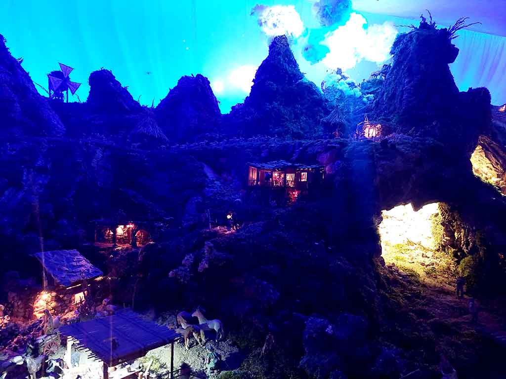 Belén de Cerezales del Condado con las luces apagadas y solo iluminación en algunas casas y cuevas.