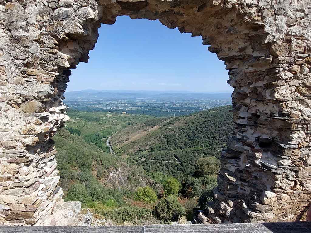 Vistas del paisaje a través de un hueco en el muro del Castillo de Cornatel