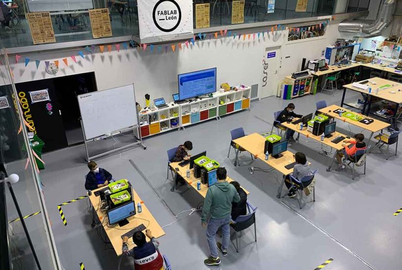 Vista general de una de las salas de Fab Lab León, con niños trabajando en sus proyectos