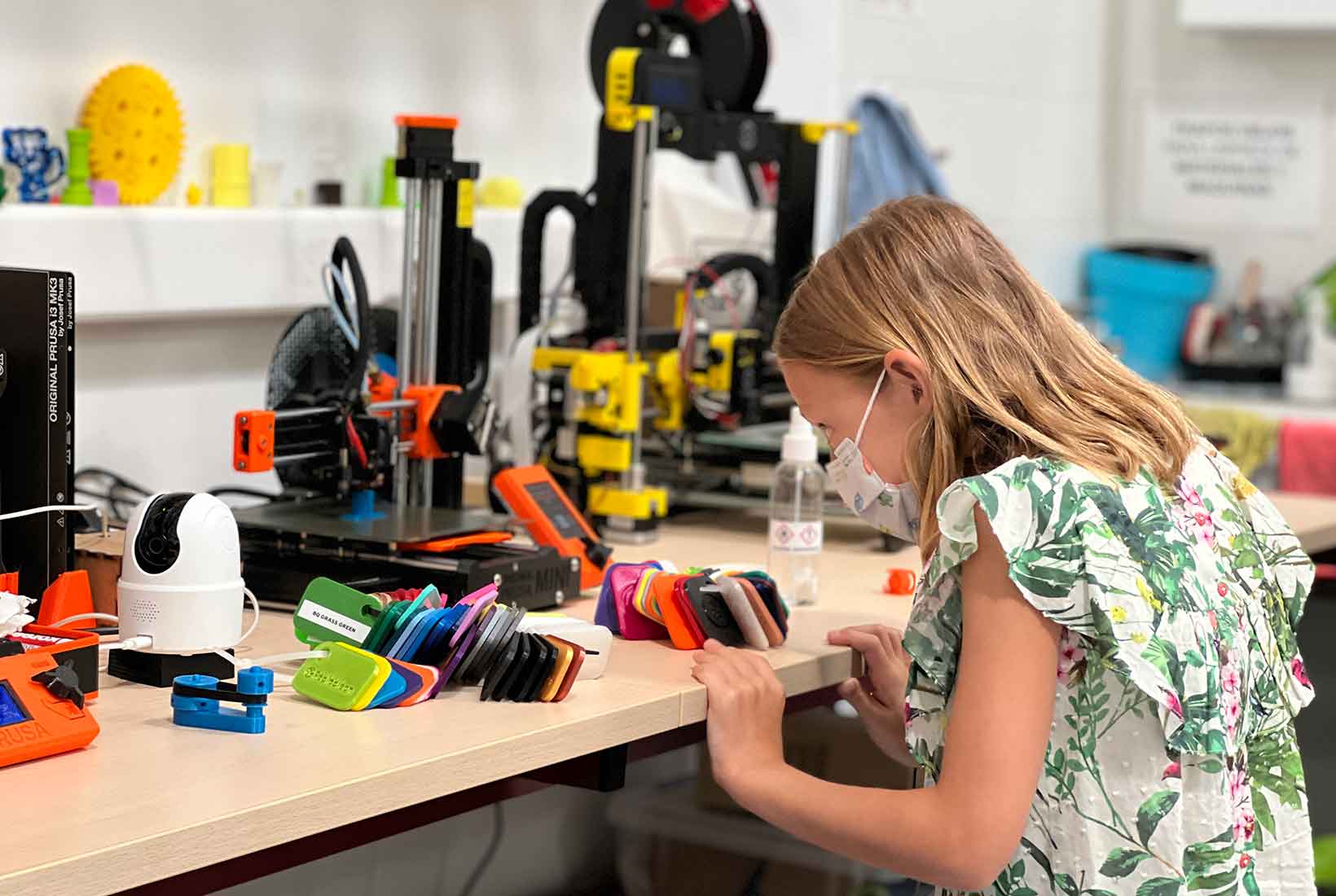 Una niña comprueba el trabajo de una impresora 3D en la Escuela de Verano de Fab Lab León