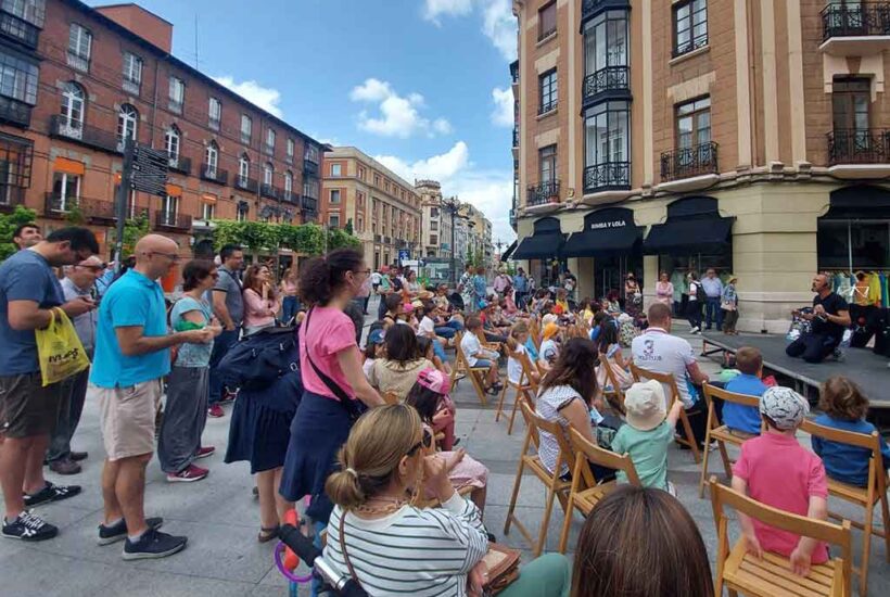Numerosas personas escuchan un cuentacuentos en la calle Ordoño II