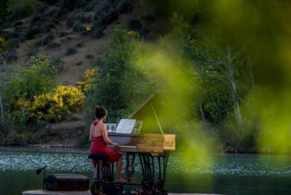 Una mujer toca el piano sobre una plataforma flotante