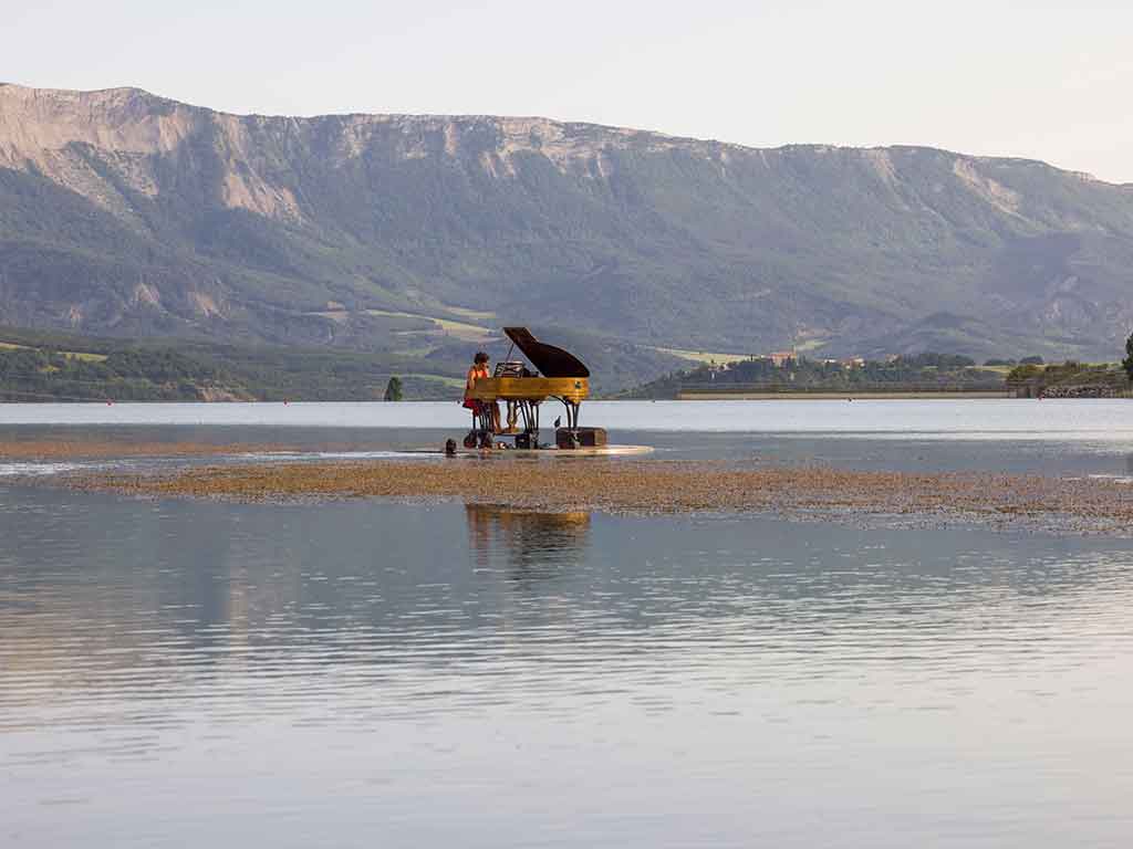 Una mujer toca el piano flotante sobre el agua del Piano du Lac