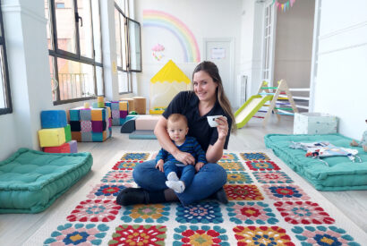 Irene, propietaria de la empresa Limalimón posa en su nuevo local, una cafetería para familias, junto a su hijo en la sala de bebés.