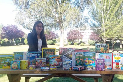 Jessica Melgar posa en un parque junto a numerosos juegos de mesa para su tienda on line Neurojuegos