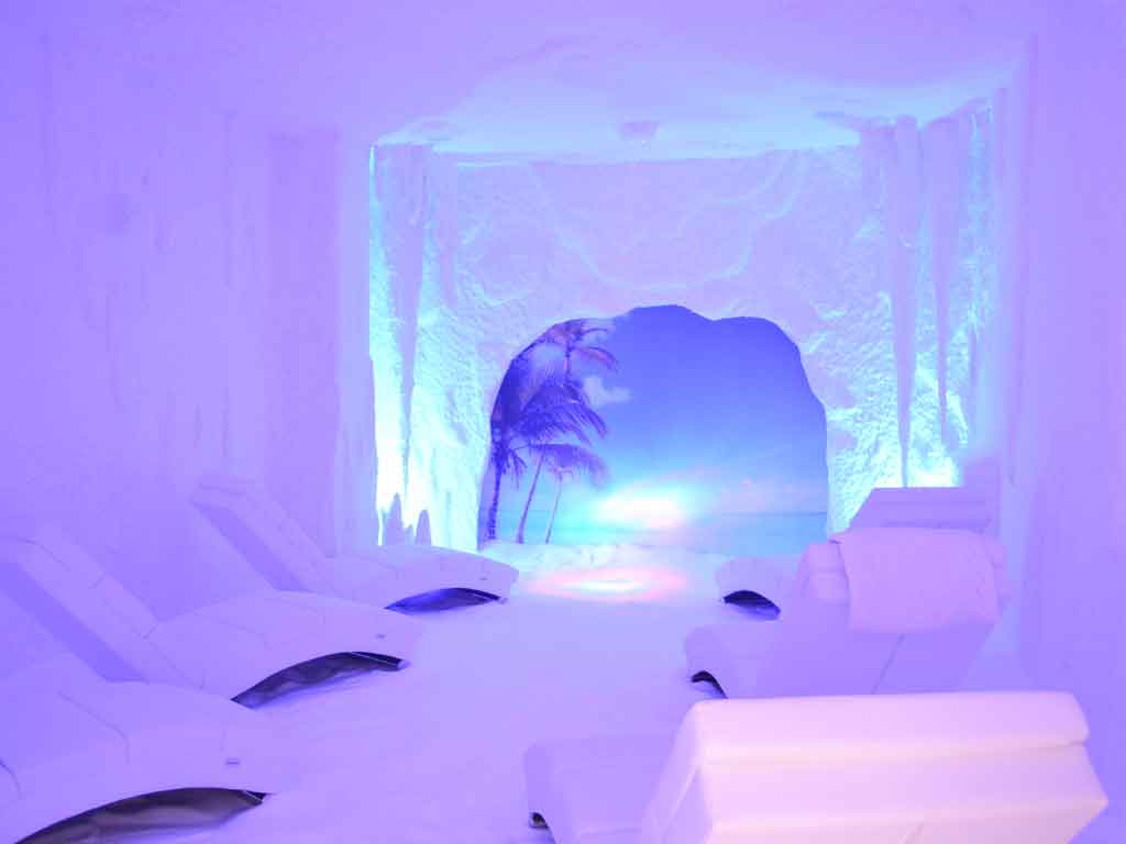Seis hamacas en una sala blanca llena de sal de Salt Room León donde se aplica la haloterapia