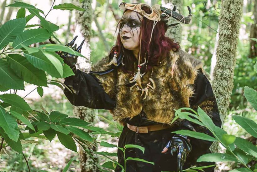 Un personaje enmascarado mira la vegetación durante la visita teatraliazada de El Soto de Villar